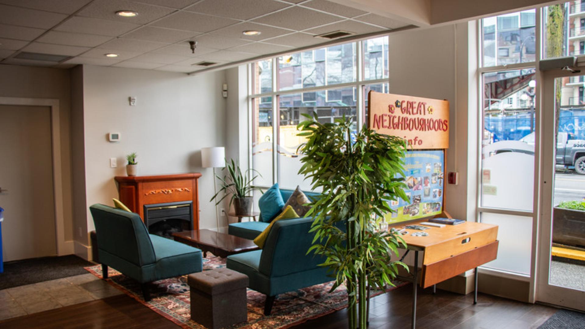 Interior space with three small couches, fireplace, large windows and decor